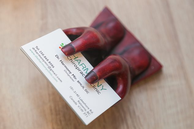 A pair of red shoes holding a business card.