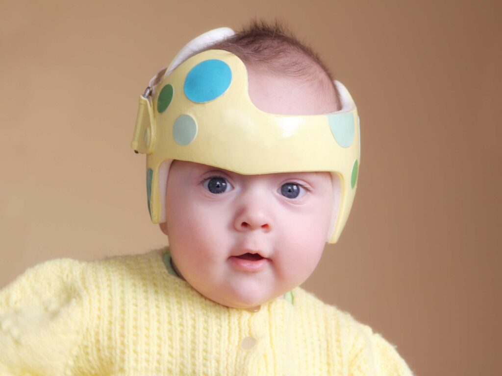 A baby wearing a helmet with polka dots on it.