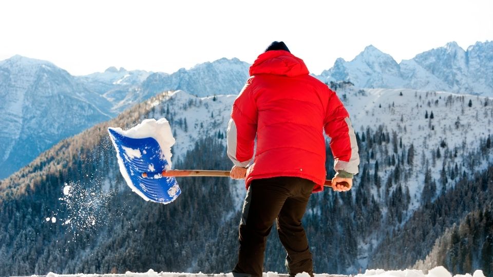 A person holding an axe in the snow.