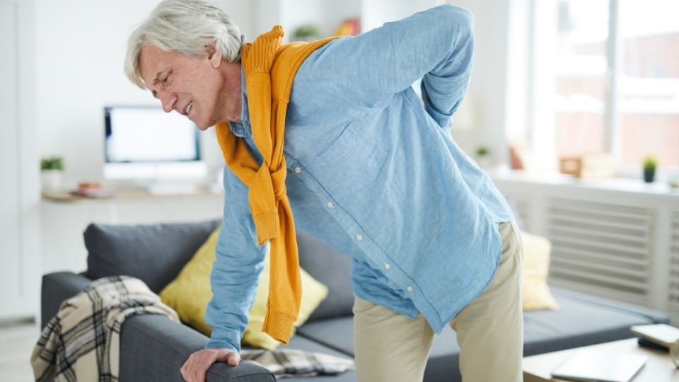 A man with his back turned and holding something in his hand.