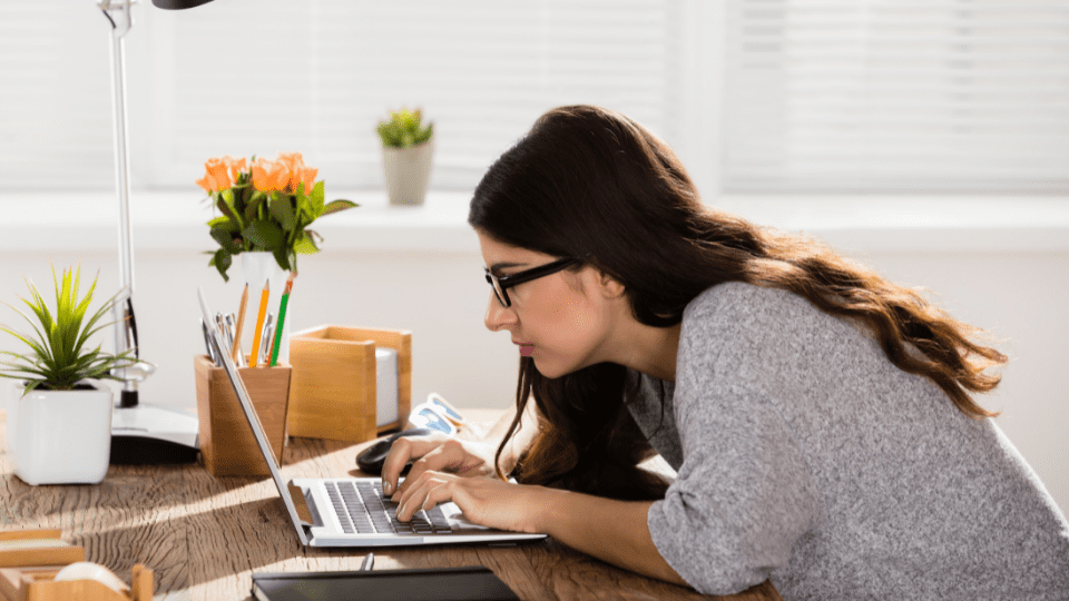 A woman is using her laptop on the desk