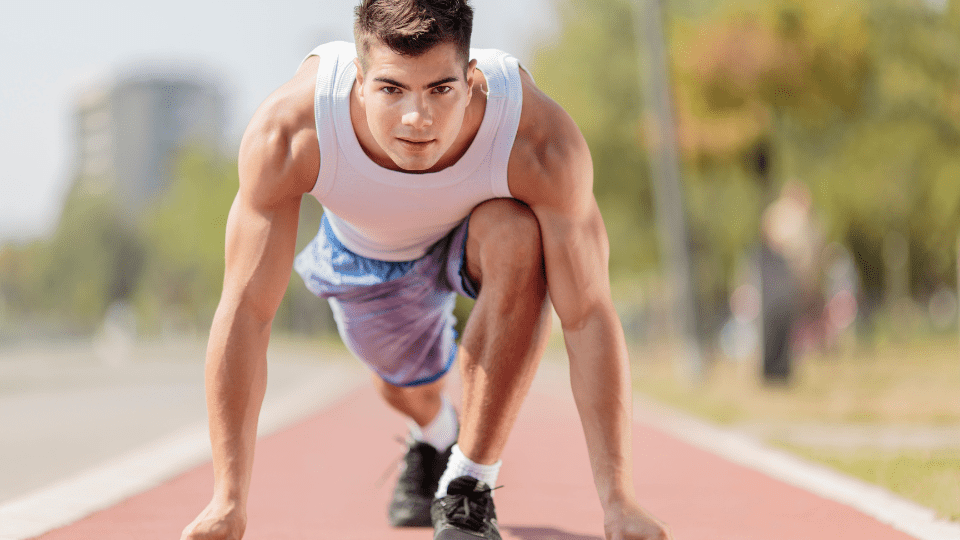 A man is crouching down on the track